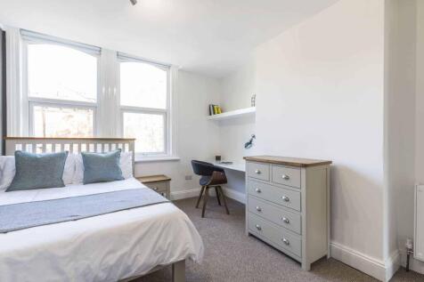 A bright and inviting bedroom featuring a comfo...