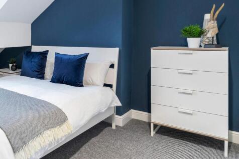 A spacious, well-maintained bedroom featuring a...