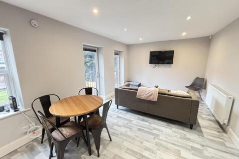 A bright and modern living room featuring large...