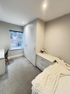 A well-lit bedroom with a large window that all...