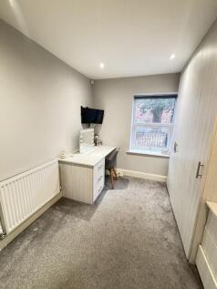 A cozy student bedroom featuring a large window...