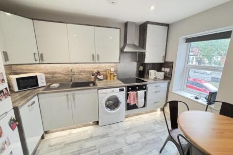 Bright and modern kitchen with ample cabinet st...