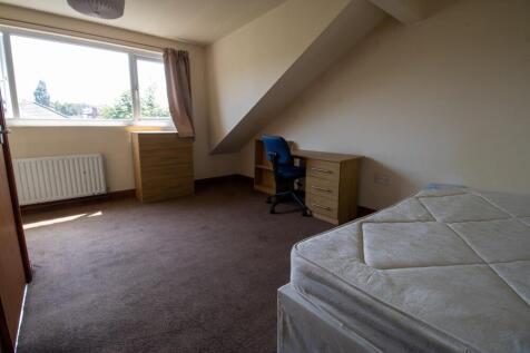 A spacious bedroom with a large bed, natural li...