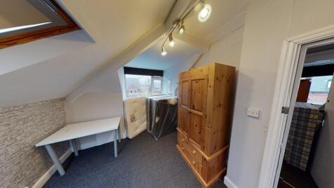 A cozy bedroom featuring a wooden wardrobe, a w...