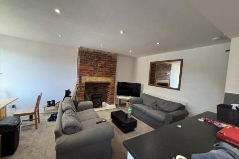 A spacious and well-lit living room featuring c...