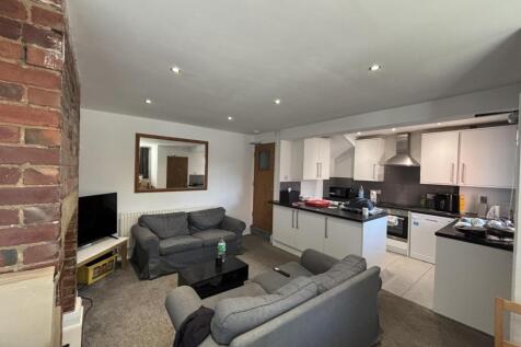 A spacious and well-lit living room with modern...