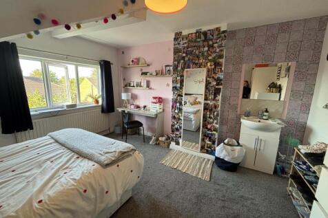 A bright and welcoming bedroom featuring a neat...