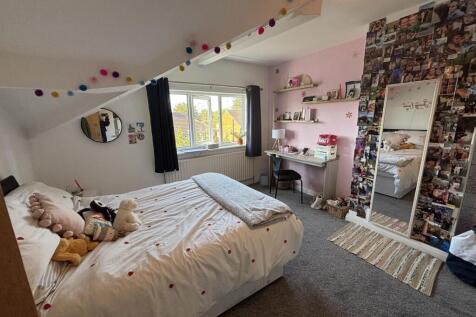 A cozy and bright bedroom featuring a comfortab...