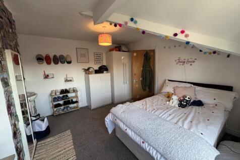 A bright and inviting bedroom featuring a comfo...