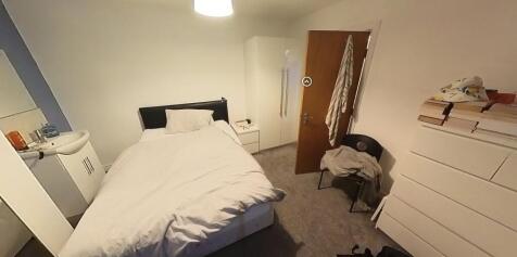 A cozy bedroom featuring a comfortable bed, a b...