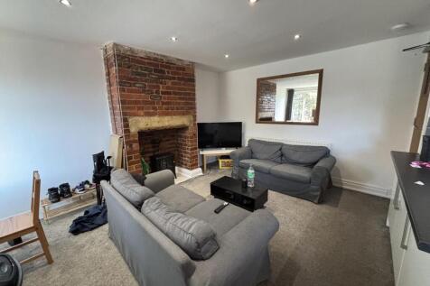 A spacious, well-lit living room featuring comf...