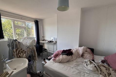 A softly lit bedroom featuring a bed with pink ...