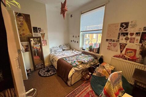 A cozy double bedroom with natural light stream...