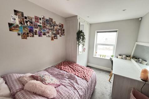 A bright and inviting bedroom featuring a cozy ...