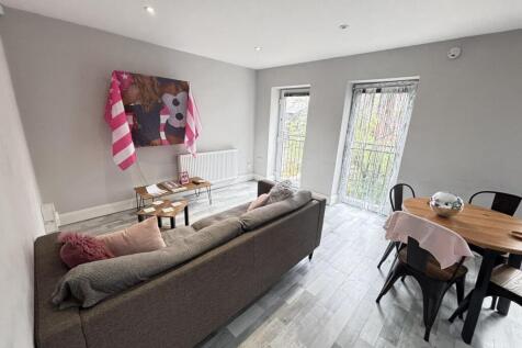 A spacious and well-lit living room featuring m...