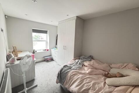 A bright and airy bedroom featuring a double be...