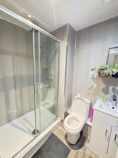 A clean and modern bathroom featuring a shower ...