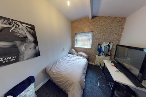 A cozy, tidy bedroom featuring a comfortable si...