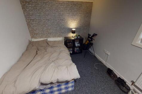 A modest bedroom with a double bed positioned a...