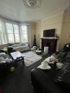 A lived-in living room with a large window prov...