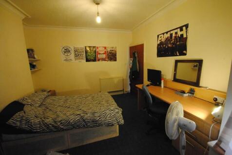 A cozy single bedroom featuring a comfortable b...