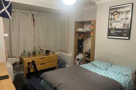 A cozy bedroom featuring a double bed, a study ...