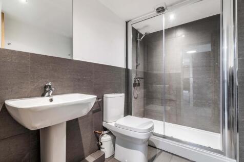 A modern, clean bathroom featuring a shower enc...
