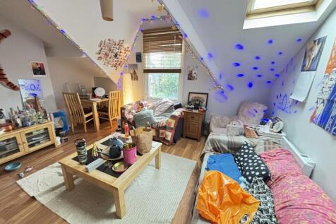 A spacious and well-lit living room featuring m...