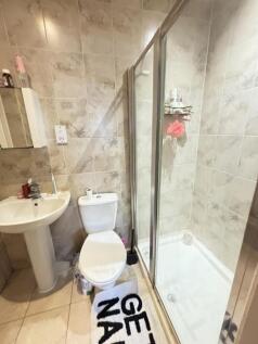 A modern bathroom featuring a spacious shower e...