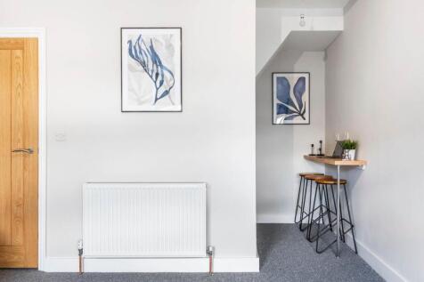A bright and tidy living room featuring a white...