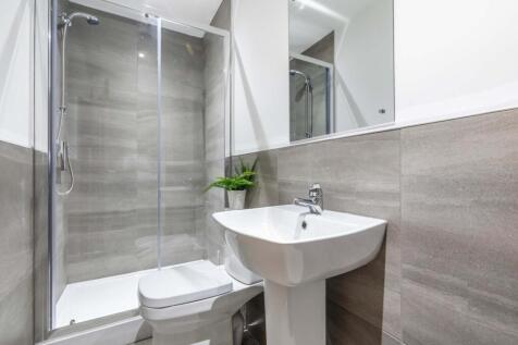 A modern clean bathroom featuring a shower encl...