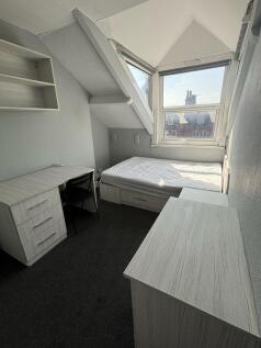 A compact student bedroom featuring a single be...