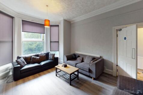 Spacious and well-lit living room featuring con...