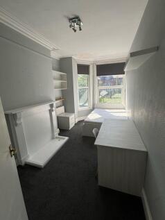 A bright and tidy study space with a large wind...