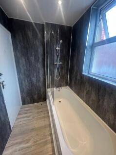 Contemporary bathroom with a full-length bathtu...