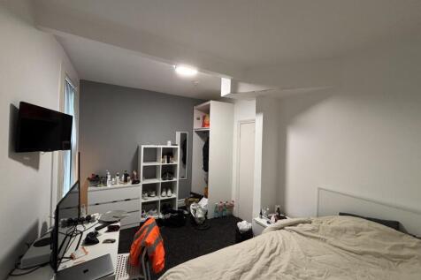 A cozy bedroom featuring a neatly made bed, a s...