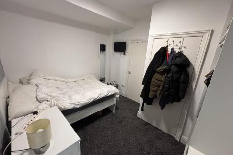 A cozy bedroom featuring a double bed with whit...