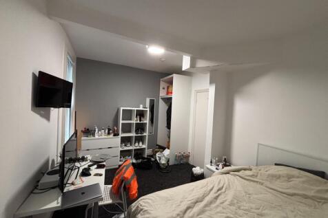 A cozy bedroom featuring a double bed with a wh...