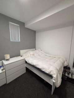 A well-lit and tidy double bedroom with a comfo...