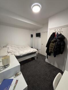 A tidy and comfortable student bedroom featurin...