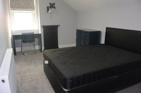 A spacious master bedroom featuring a large bed...