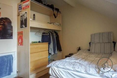 A cozy single bedroom featuring a neatly made b...