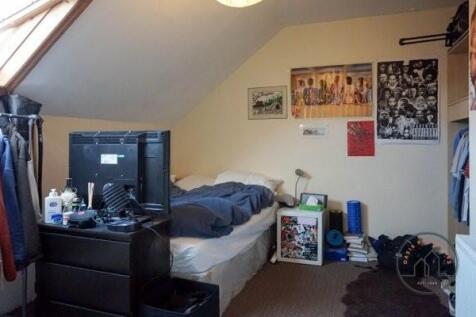 A cozy bedroom featuring a bed with storage, a ...