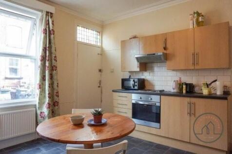 A cozy kitchen area featuring wooden cabinets, ...