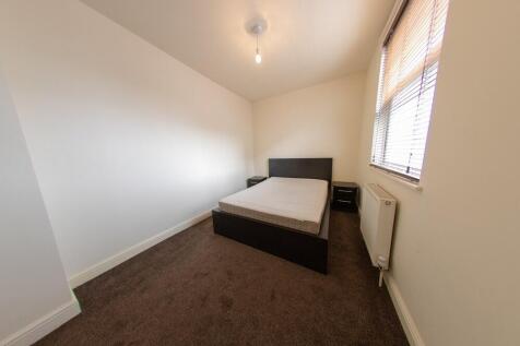 A spacious and tidy double bedroom featuring a ...