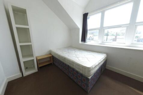 A cozy single bedroom with a comfortable bed po...