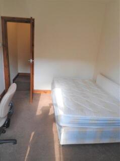 A modestly sized bedroom featuring a single bed...
