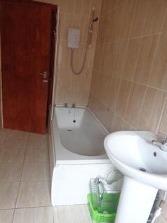 Bright tiled bathroom with a built-in bath, ped...