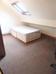 A spacious, well-lit double bedroom featuring a...