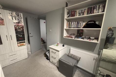 A neatly organized bedroom with a comfortable b...